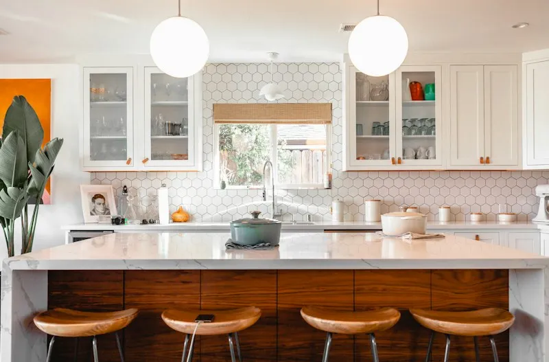 Renovated kitchen with a white island and wood bar stools